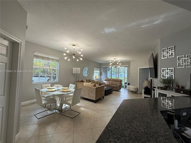 dining area featuring light tile patterned floors, a textured ceiling, and an inviting chandelier