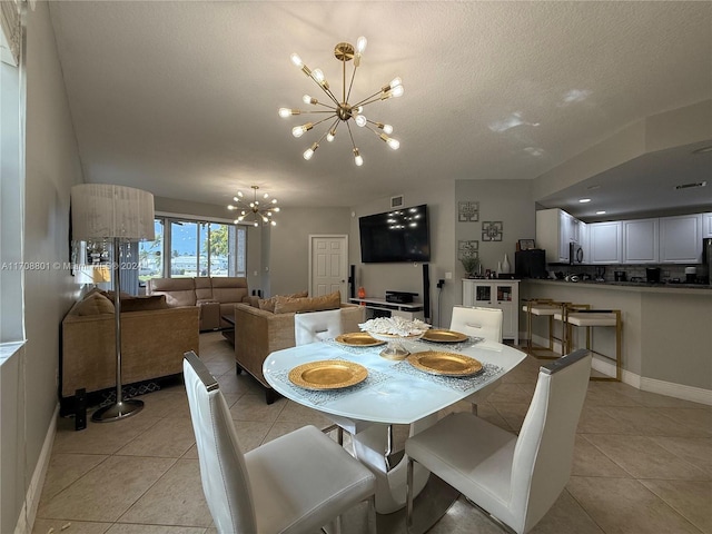 tiled dining room featuring a textured ceiling and an inviting chandelier