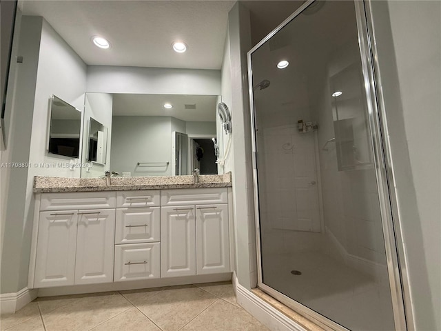 bathroom featuring tile patterned flooring, vanity, and walk in shower