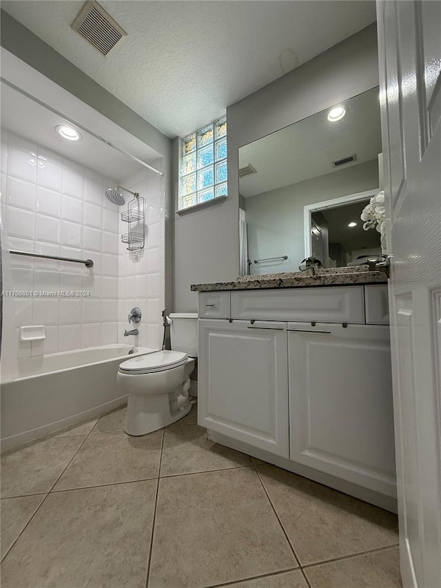 full bathroom featuring tile patterned flooring, a textured ceiling, vanity, and tiled shower / bath