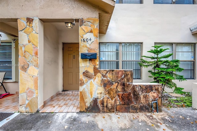 doorway to property featuring stucco siding