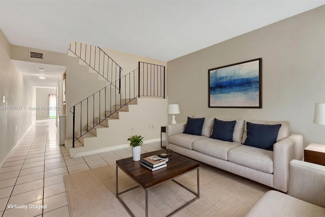 living room featuring stairway, baseboards, visible vents, and light tile patterned flooring