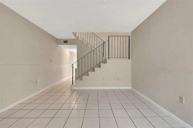 spare room featuring visible vents, stairs, baseboards, and light tile patterned flooring