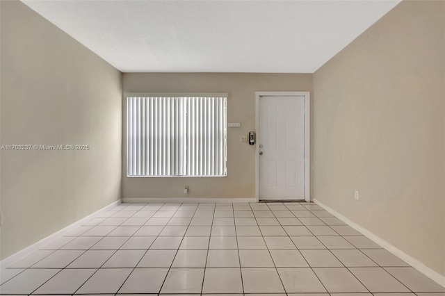 unfurnished room featuring baseboards and light tile patterned floors