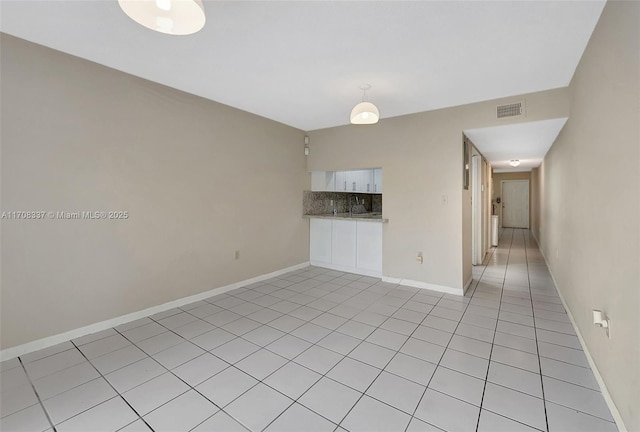 unfurnished room featuring light tile patterned floors, visible vents, and baseboards