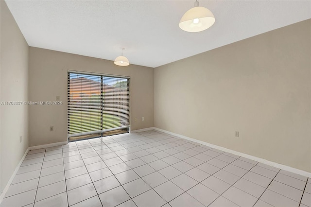 unfurnished room featuring baseboards and light tile patterned floors