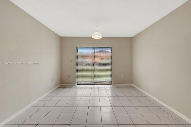 empty room with baseboards and light tile patterned flooring