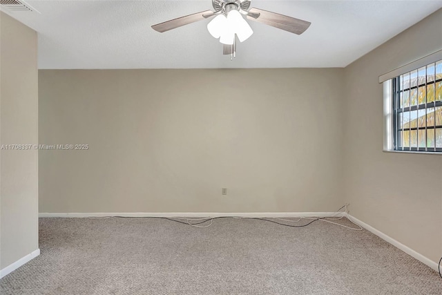 carpeted spare room featuring a ceiling fan, visible vents, and baseboards