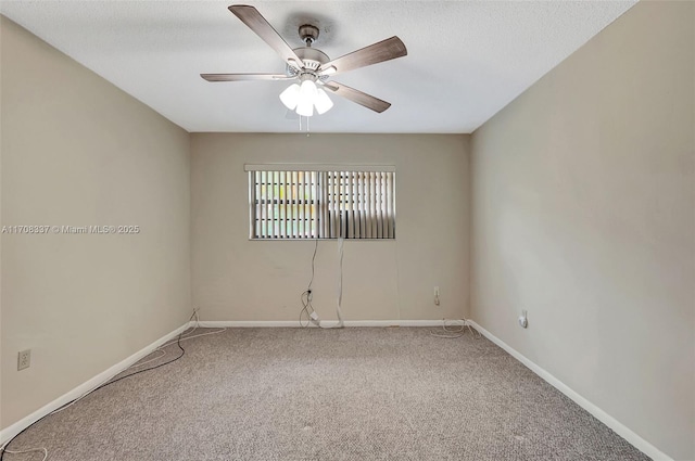 carpeted spare room featuring a textured ceiling, baseboards, and a ceiling fan