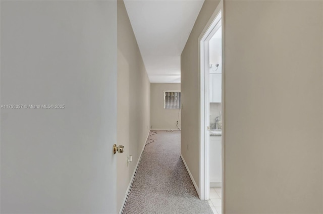 hallway with light carpet and baseboards