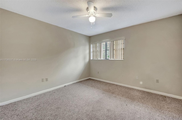 carpeted spare room with a ceiling fan, baseboards, and a textured ceiling