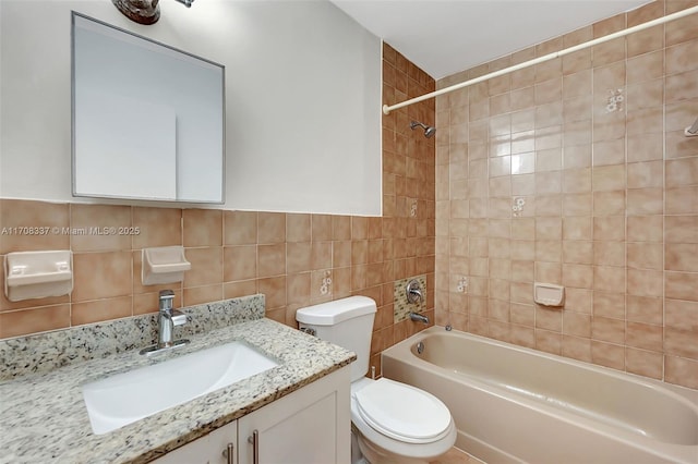 full bath featuring toilet, shower / bathtub combination, vanity, and tile walls