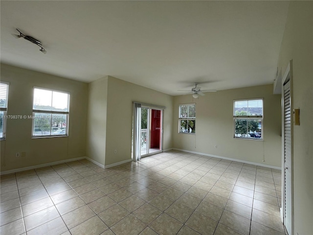 tiled spare room featuring ceiling fan