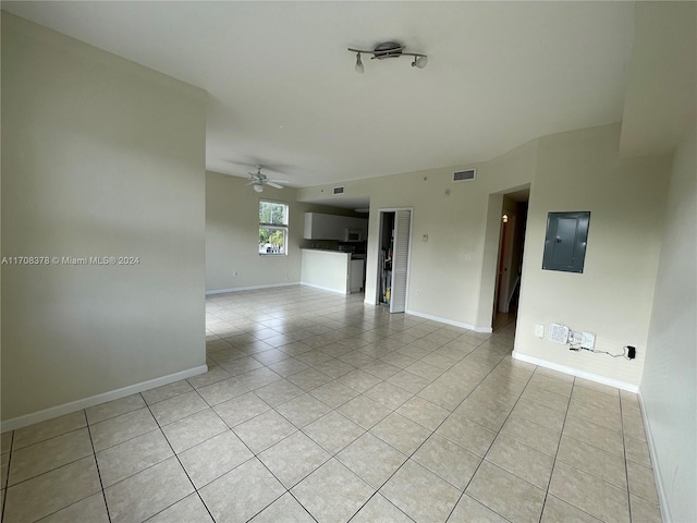 tiled spare room featuring electric panel and ceiling fan