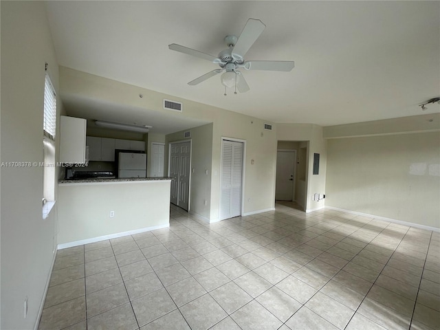 unfurnished living room featuring ceiling fan and light tile patterned floors