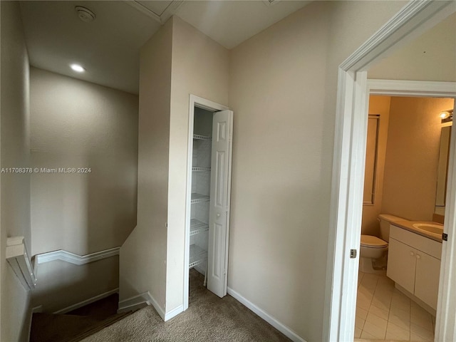 hallway featuring carpet floors and sink