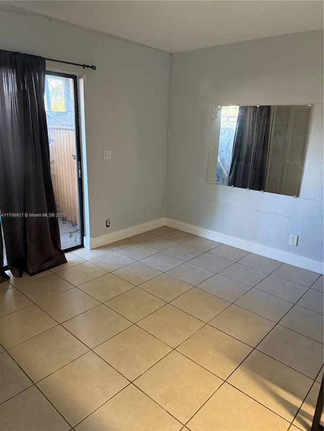 unfurnished room featuring baseboards and light tile patterned floors