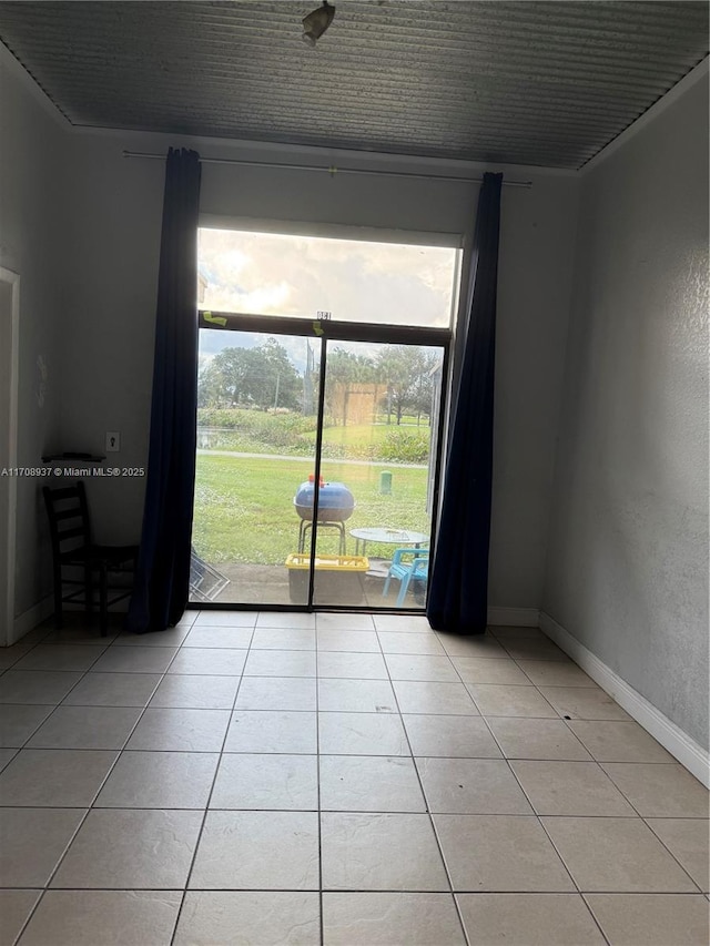 unfurnished room with baseboards and light tile patterned floors