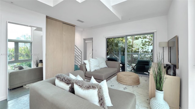 living room featuring visible vents, plenty of natural light, and stairway