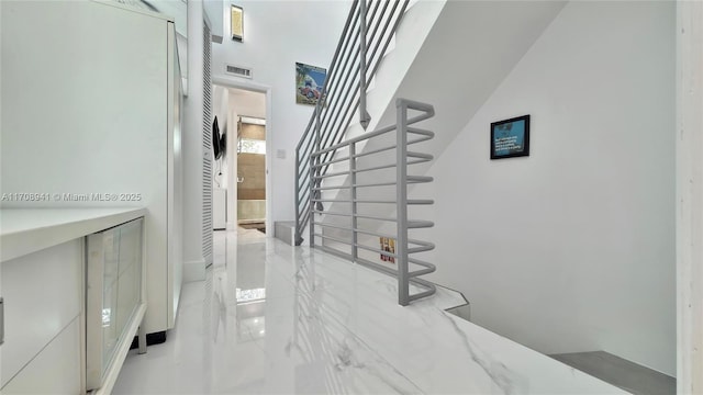 stairs with visible vents and marble finish floor