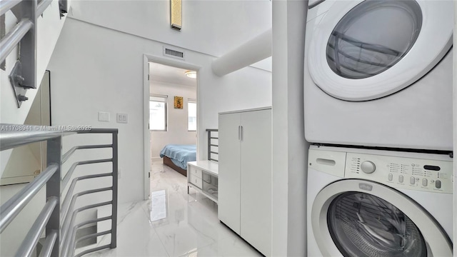 734 Michigan Ave Unit 7And 6, Miami Beach, FL 33139 - laundry room featuring light marble finish floors and stacked washing machine and dryer