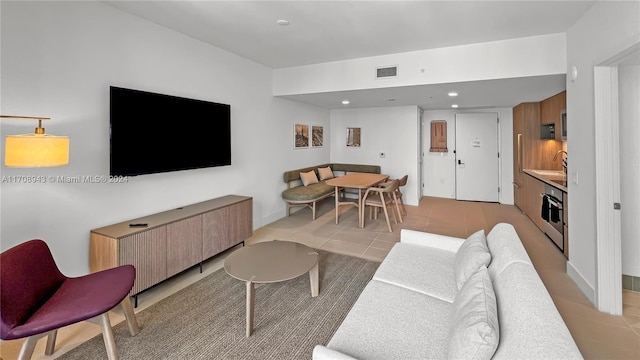 living room featuring light tile patterned floors and sink