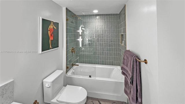 bathroom featuring tiled shower / bath combo and toilet