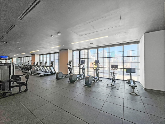 gym with floor to ceiling windows and a textured ceiling