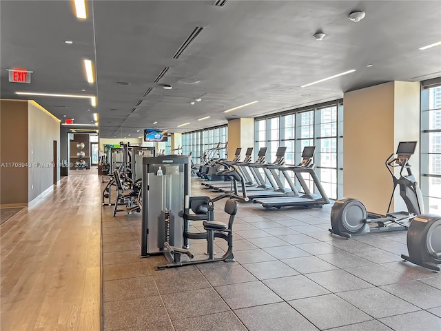 workout area featuring hardwood / wood-style flooring and a wall of windows