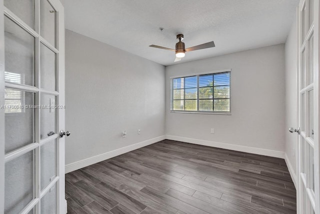 unfurnished room featuring ceiling fan, dark hardwood / wood-style flooring, a textured ceiling, and french doors