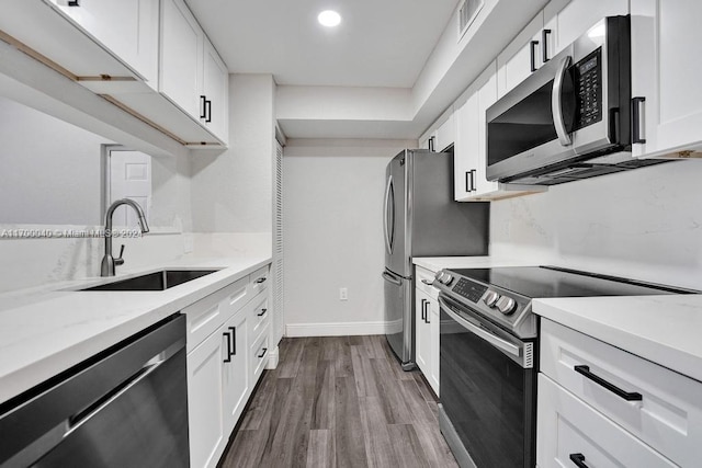 kitchen featuring white cabinets, appliances with stainless steel finishes, and wood-type flooring