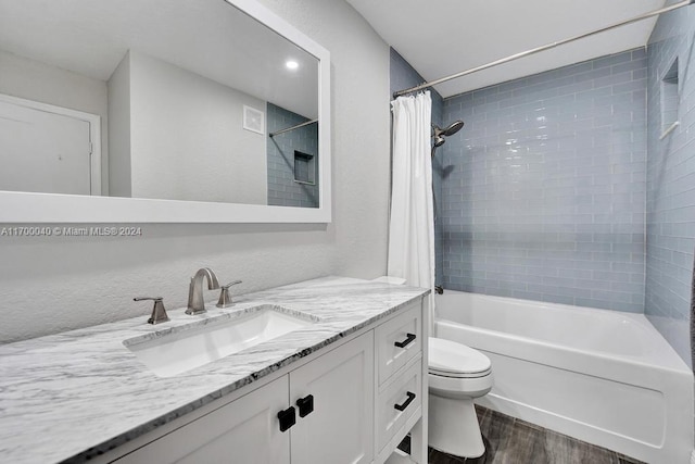 full bathroom with hardwood / wood-style floors, vanity, toilet, and shower / tub combo with curtain