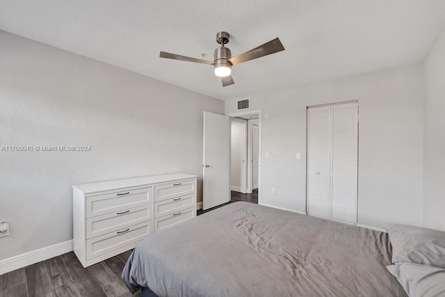 bedroom featuring ceiling fan, a closet, and dark wood-type flooring