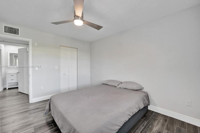 bedroom featuring ceiling fan, wood-type flooring, and a closet