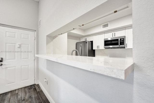 kitchen featuring dark hardwood / wood-style flooring, white cabinetry, and stainless steel appliances