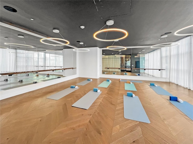 workout room featuring parquet flooring and a textured ceiling