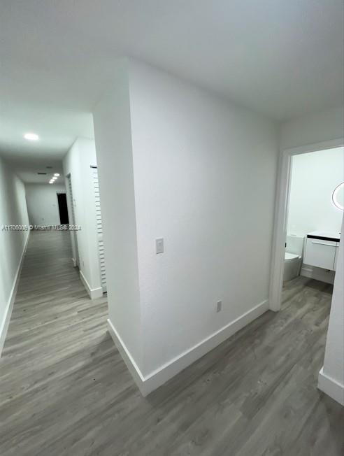 hallway with hardwood / wood-style flooring