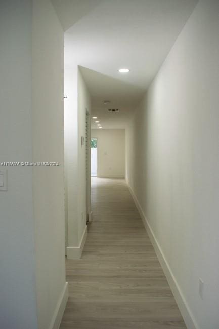 corridor with light hardwood / wood-style flooring