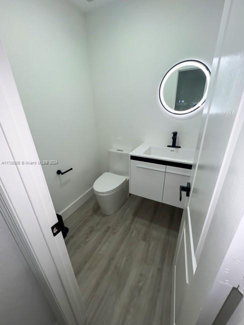 bathroom featuring vanity, wood-type flooring, and toilet