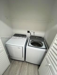 laundry area featuring washer and dryer and light hardwood / wood-style floors