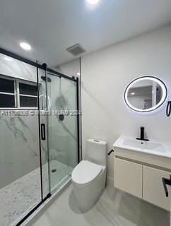 bathroom with a shower with door, vanity, and toilet