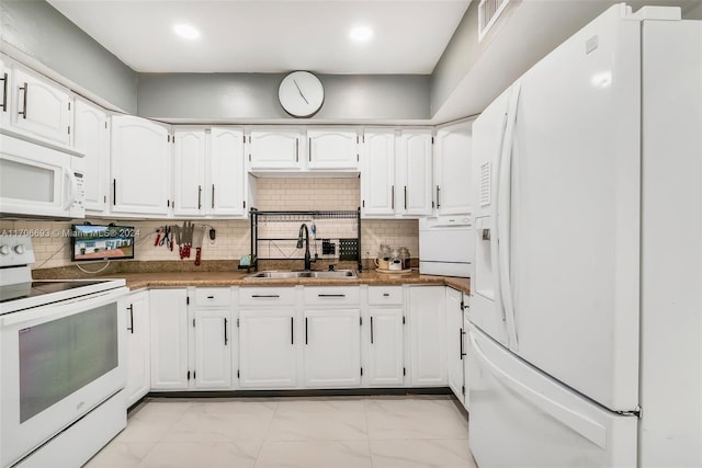 kitchen with decorative backsplash, white appliances, white cabinetry, and sink