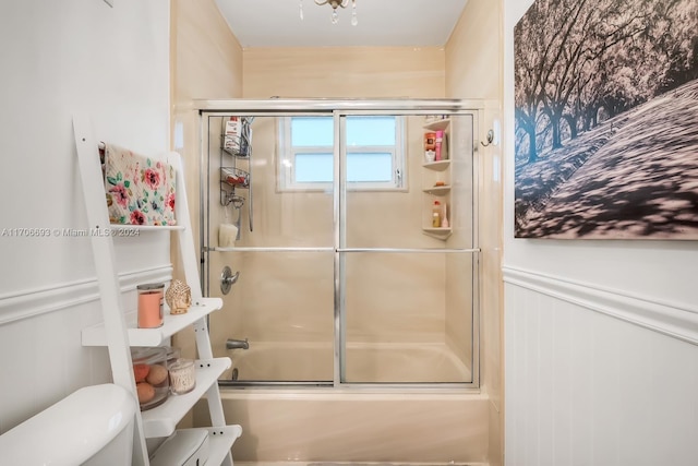 bathroom with enclosed tub / shower combo and toilet