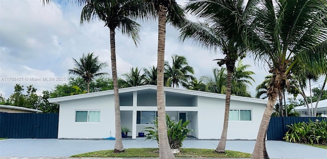 view of front of property featuring fence and stucco siding