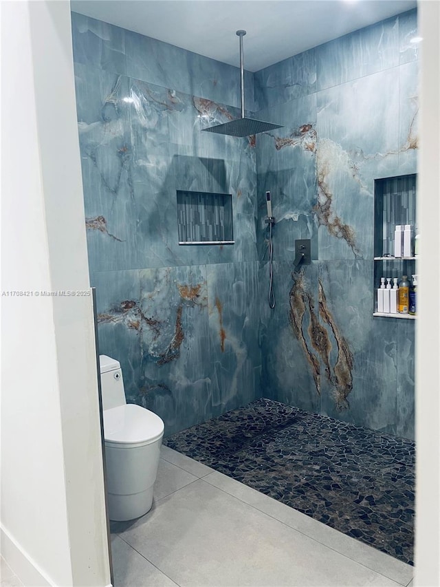 bathroom featuring a marble finish shower, toilet, and tile patterned floors