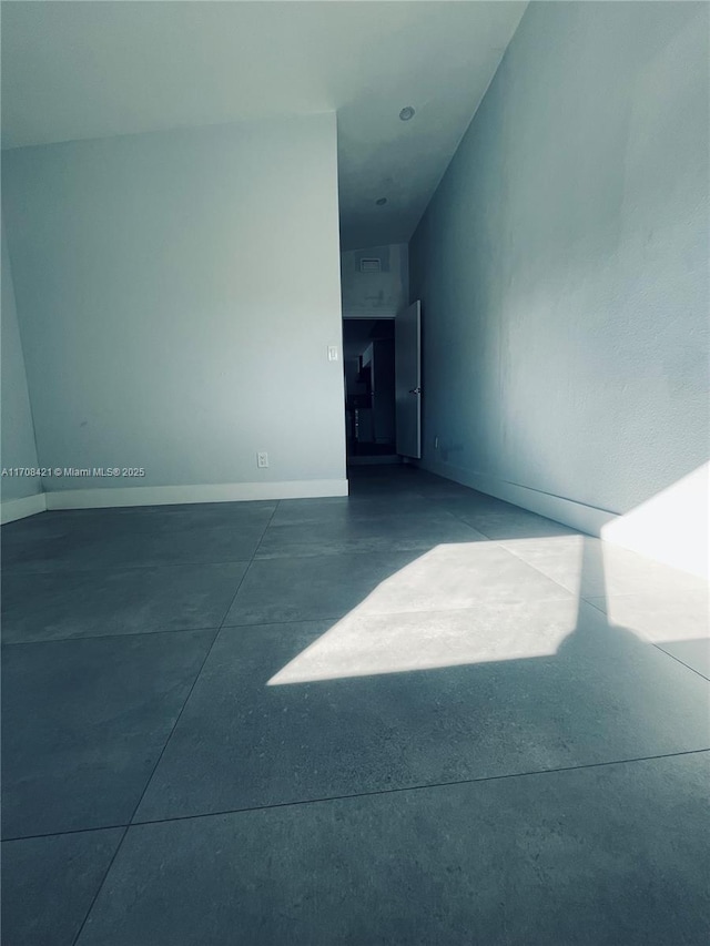 empty room featuring concrete floors and baseboards