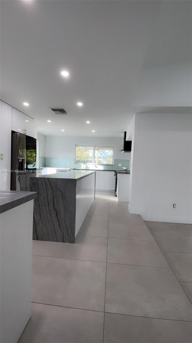 kitchen with visible vents, light tile patterned flooring, white cabinets, ventilation hood, and modern cabinets