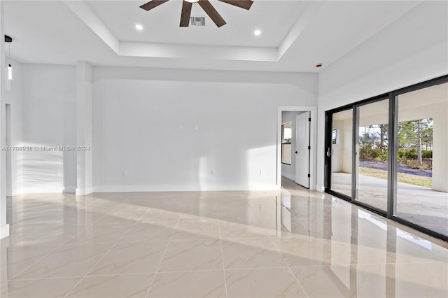 spare room featuring ceiling fan and a tray ceiling