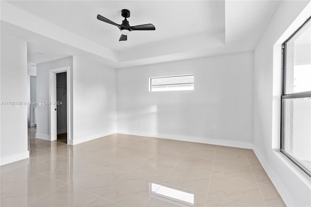 spare room featuring ceiling fan and a tray ceiling