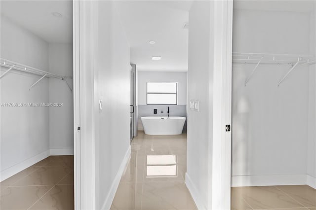 interior space with a washtub and tile patterned flooring